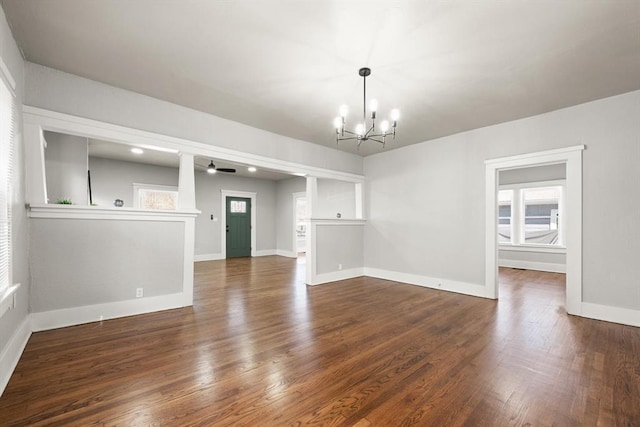 interior space featuring baseboards, a chandelier, and dark wood-style flooring