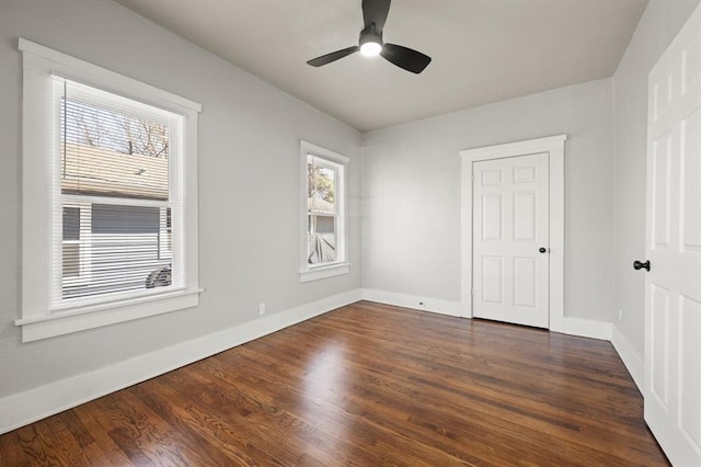 unfurnished bedroom featuring dark wood finished floors, baseboards, and ceiling fan