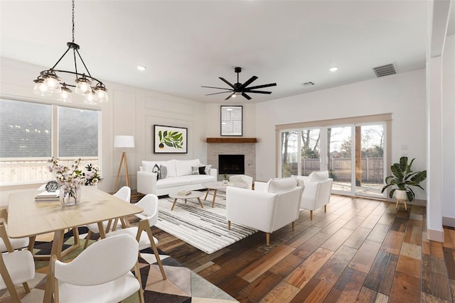 living room with dark wood-type flooring, a fireplace, visible vents, and recessed lighting