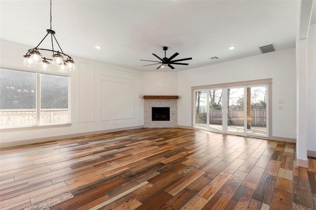 unfurnished living room with a fireplace, visible vents, and wood finished floors