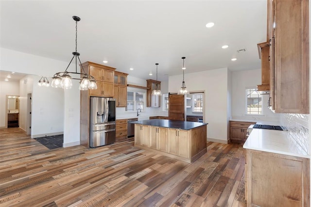 kitchen with stainless steel appliances, wood finished floors, visible vents, and a center island