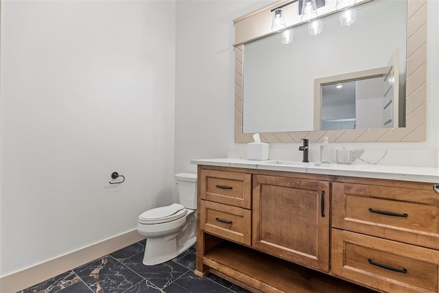 bathroom featuring toilet, marble finish floor, baseboards, and vanity