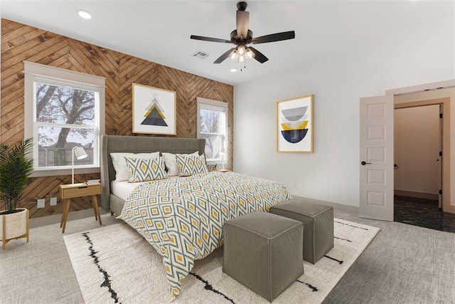 bedroom with wooden walls, baseboards, visible vents, carpet floors, and recessed lighting