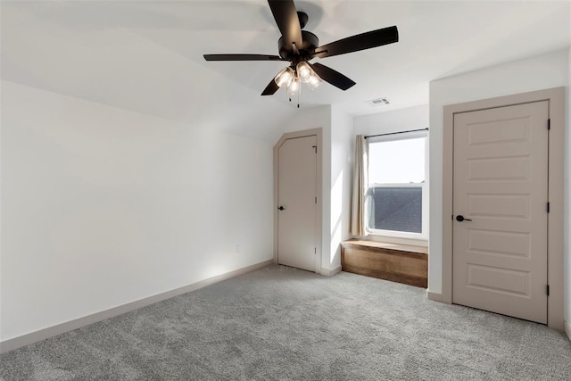 additional living space featuring light carpet, lofted ceiling, visible vents, and baseboards