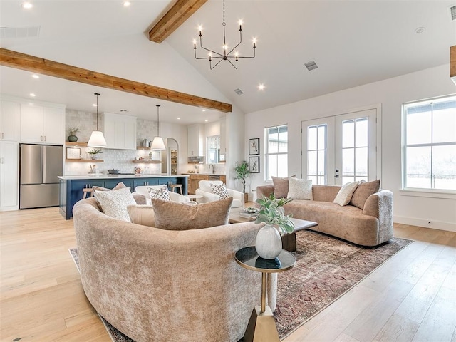 living room featuring high vaulted ceiling, visible vents, light wood-style floors, beamed ceiling, and an inviting chandelier