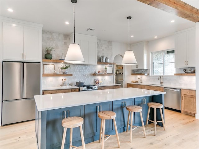 kitchen featuring appliances with stainless steel finishes, visible vents, light wood-style flooring, and open shelves