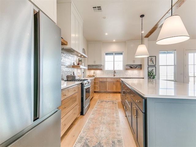 kitchen with visible vents, decorative backsplash, light wood-style flooring, stainless steel appliances, and light countertops