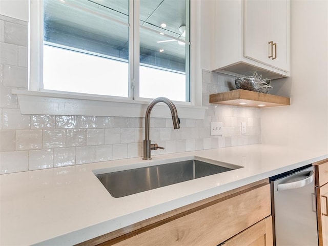 kitchen with light countertops, decorative backsplash, a sink, ceiling fan, and dishwasher