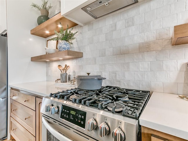 kitchen with open shelves, light countertops, decorative backsplash, appliances with stainless steel finishes, and under cabinet range hood