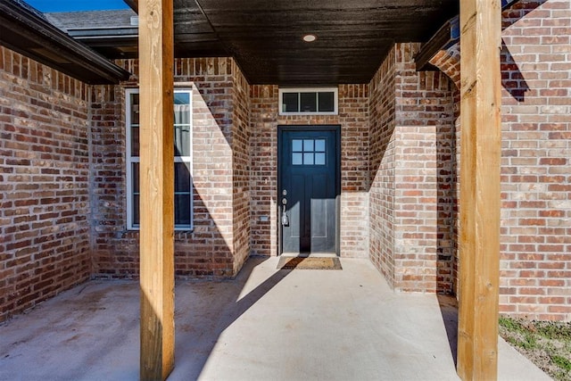 view of exterior entry with brick siding