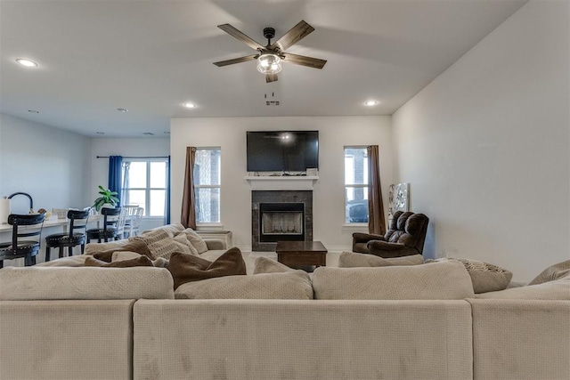 living area featuring a ceiling fan, a wealth of natural light, a tiled fireplace, and recessed lighting