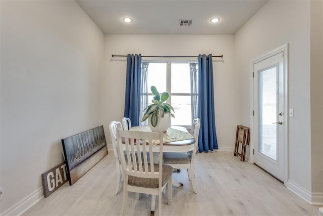 dining area with light wood finished floors, visible vents, and baseboards