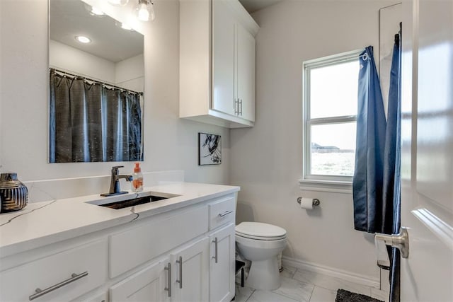 bathroom with curtained shower, toilet, vanity, baseboards, and marble finish floor