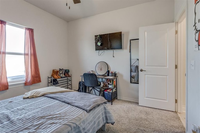 bedroom with light carpet, ceiling fan, and baseboards