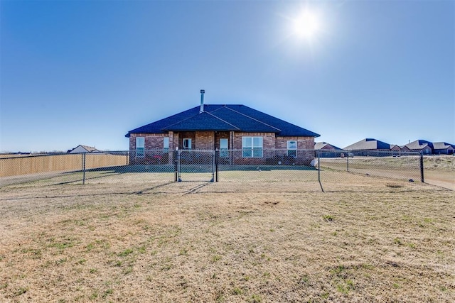 exterior space with brick siding, fence, and a front lawn