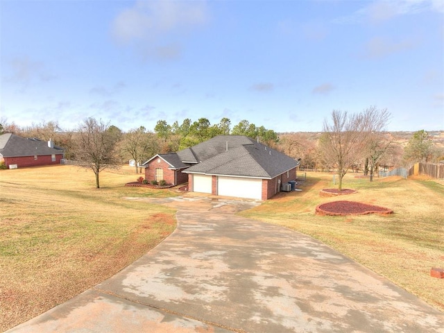 view of front of home with brick siding, central AC, a garage, driveway, and a front lawn