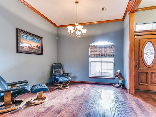 foyer entrance featuring ornamental molding, wood-type flooring, visible vents, and baseboards