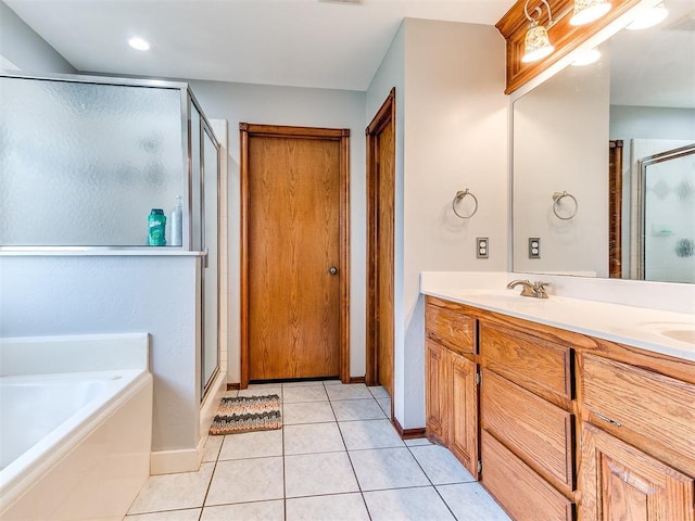 bathroom with double vanity, a stall shower, a garden tub, and tile patterned floors