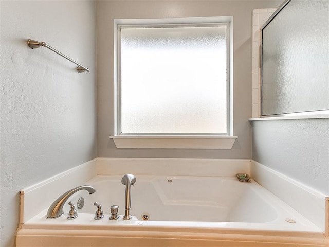 full bathroom featuring a wealth of natural light and a garden tub