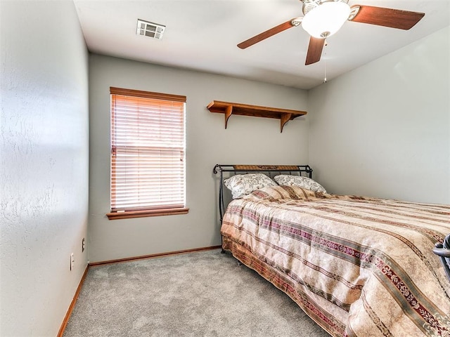 carpeted bedroom with baseboards, visible vents, and ceiling fan