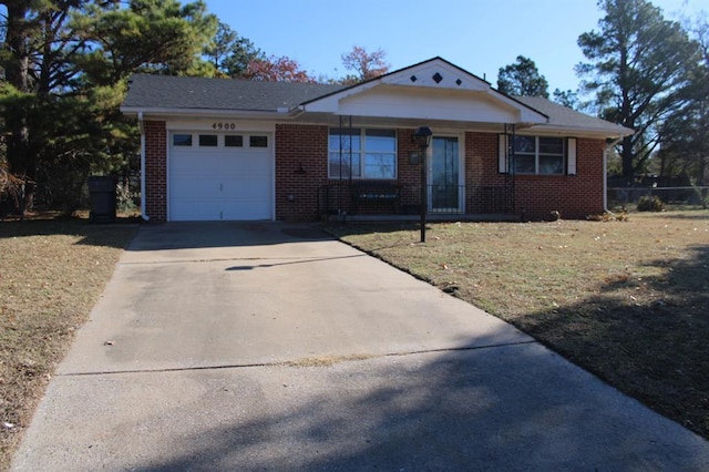 view of front of property featuring a front lawn, concrete driveway, brick siding, and an attached garage