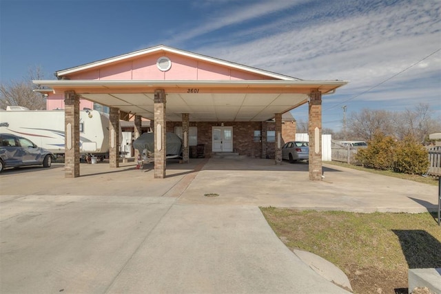 exterior space with concrete driveway and fence