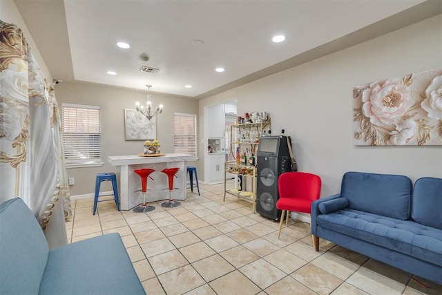 living area featuring light tile patterned floors, visible vents, baseboards, a notable chandelier, and recessed lighting