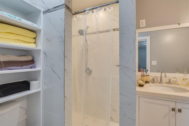 bathroom with toilet, a stall shower, and vanity