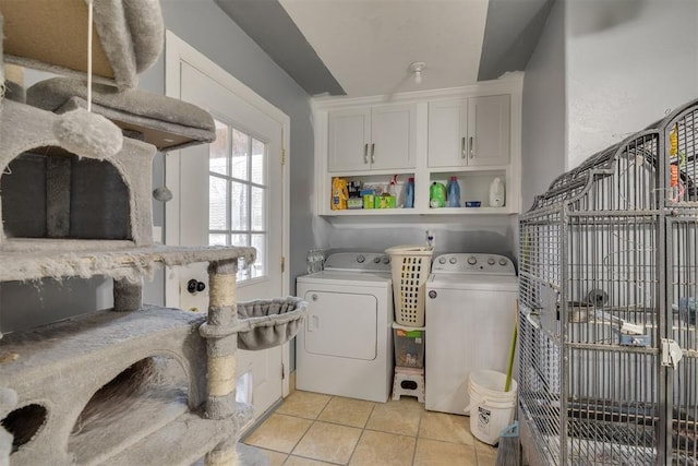 clothes washing area featuring laundry area, light tile patterned floors, and washer and clothes dryer