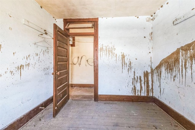 unfurnished room featuring baseboards and hardwood / wood-style flooring