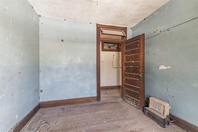 unfurnished room with wood-type flooring and baseboards