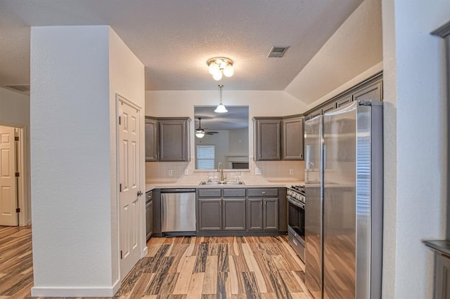 kitchen with stainless steel appliances, backsplash, a sink, and visible vents