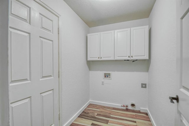 laundry room featuring light wood finished floors, hookup for a washing machine, hookup for a gas dryer, cabinet space, and baseboards