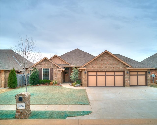 view of front of house with a garage, brick siding, driveway, and a front lawn