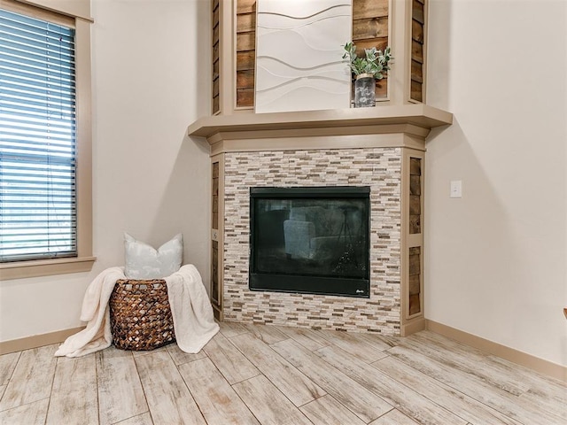 interior details with wood finish floors, a fireplace, and baseboards