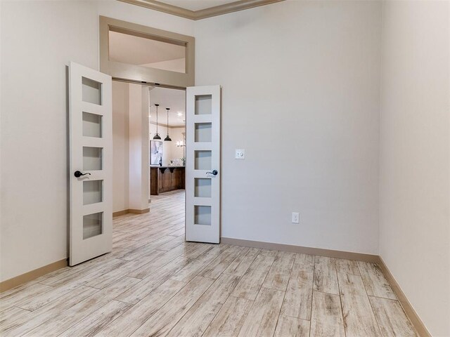 spare room with light wood-style flooring, baseboards, and french doors