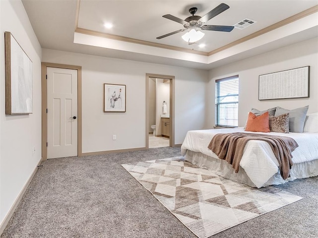 bedroom with carpet floors, visible vents, a tray ceiling, and baseboards