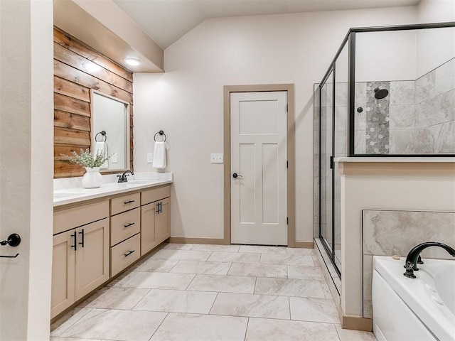 bathroom with double vanity, a sink, vaulted ceiling, a shower stall, and a bath