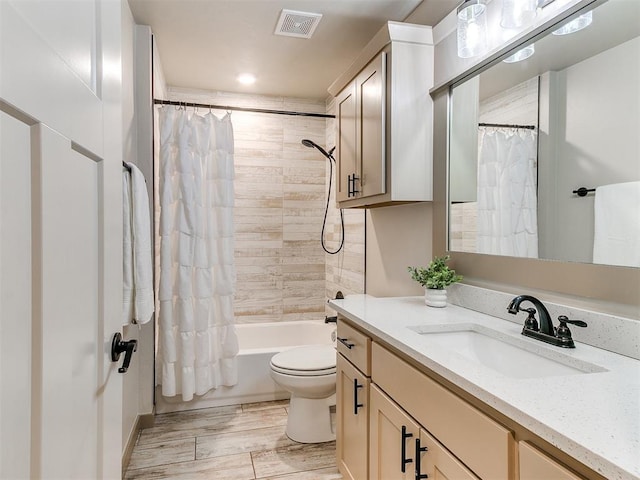 bathroom featuring visible vents, toilet, wood finished floors, shower / bathtub combination with curtain, and vanity