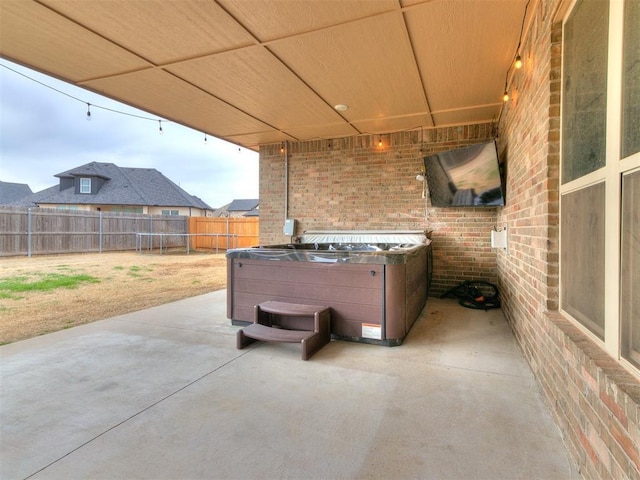 view of patio featuring a hot tub and a fenced backyard