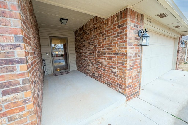 doorway to property featuring visible vents and brick siding