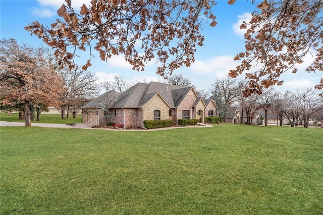 french country home with a garage, driveway, and a front yard