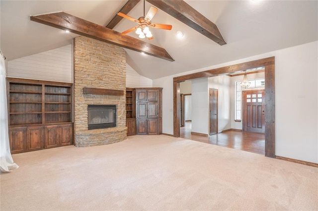 unfurnished living room featuring carpet, a fireplace, high vaulted ceiling, and beamed ceiling