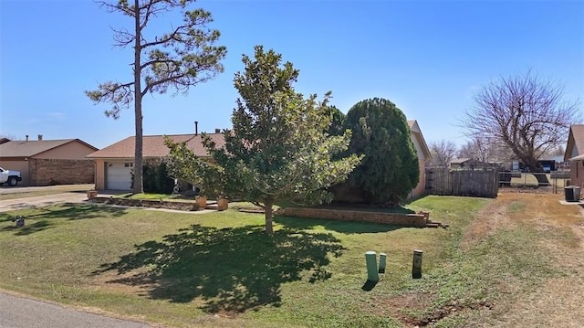 view of front of property with fence, driveway, central AC, a front lawn, and a garage