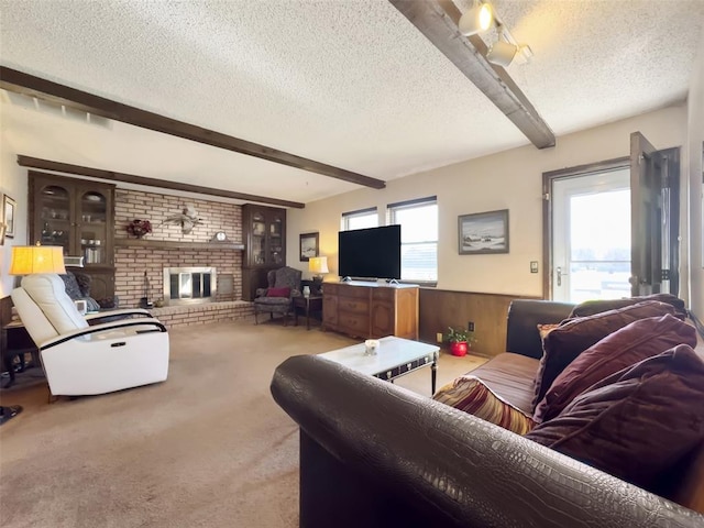 living room with beamed ceiling, a healthy amount of sunlight, and a textured ceiling