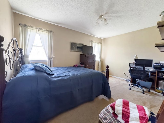 bedroom with baseboards, multiple windows, carpet, and a textured ceiling