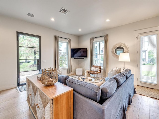 living room with light wood finished floors, baseboards, visible vents, and recessed lighting