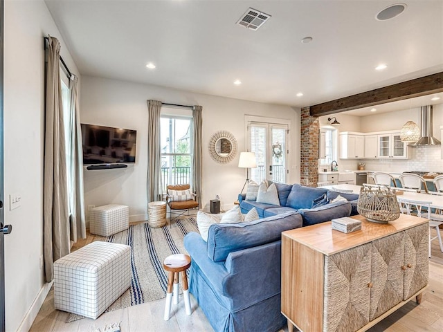 living area featuring light wood finished floors, baseboards, visible vents, and recessed lighting