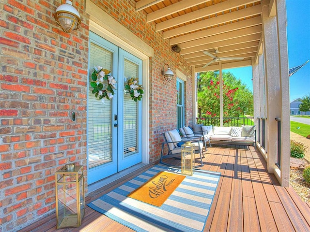 deck with outdoor lounge area, a ceiling fan, and french doors