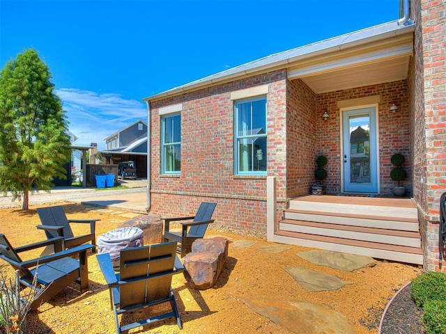 view of exterior entry with a patio and brick siding